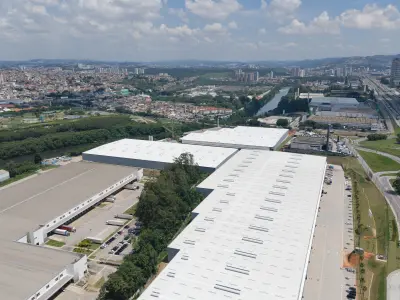 Vista aérea com galpão modular em primeiro plano, rio Tietê à esquerda e rod. Castelo Branco à direita.