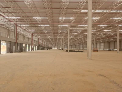 Vista interna de grande galpão modular, ainda em construção.