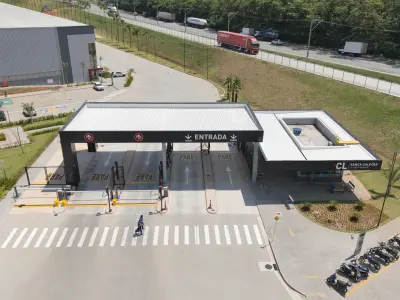 Portaria do condomínio logístico de galpões com 2 baias para entrada de caminhões e 2 para saída. Ao fundo rua Jussara.
