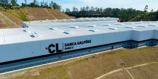 Fachada do condomínio de galpões em vista aérea.