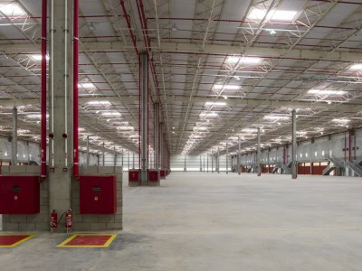 Vista interna geral de galpão, com instalação anti-incêndio em destaque..