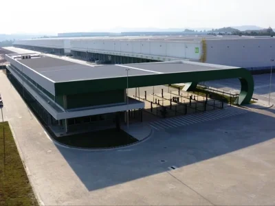 Vista da portaria do Condomínio, com galpão B2 ao fundo e estacionamento ao lado.