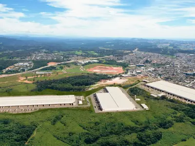 Vista aérea da região de Guarulhos com montagem fotográfica em 3D do projeto de galpões em perspectiva
