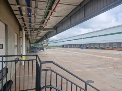 Vista a partir de escada de acesso à recepção de um módulo, mostrando rua de acesso larga e marquises para as docas.